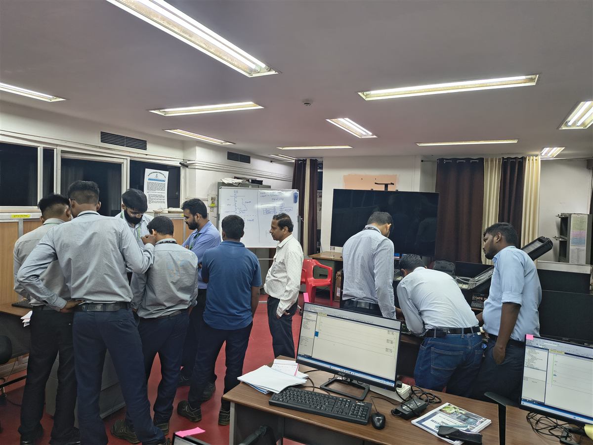 Corporate training session with engineers working on live PLC programming stations
