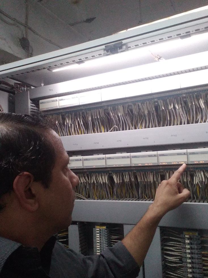 Engineer inspecting labelled I/O wiring inside a large control panel