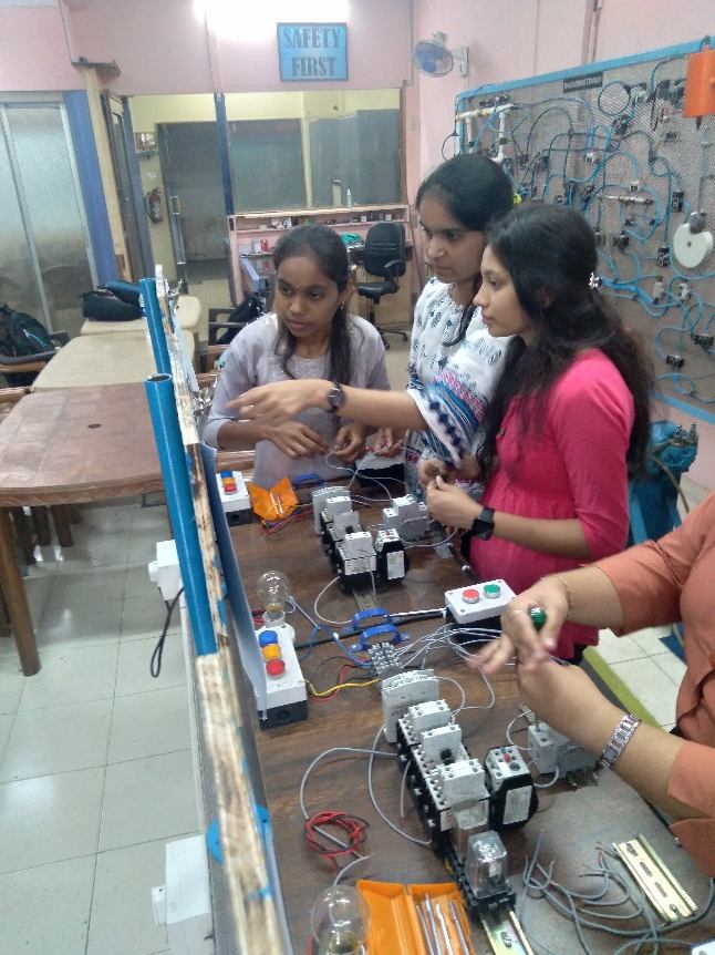 Students practising contactor and motor control wiring at training stations