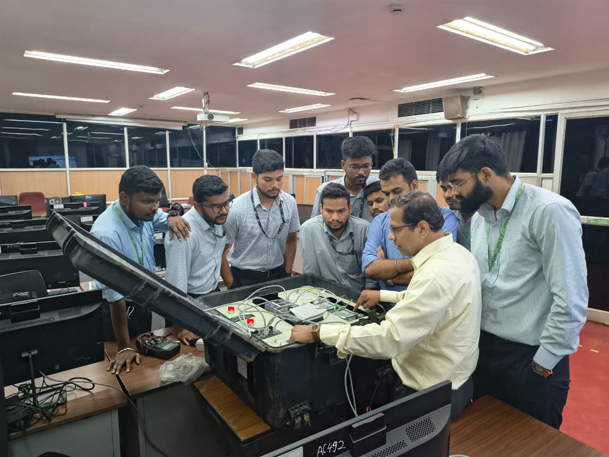 Engineers gathered around a portable PLC practice kit during a hands-on training session